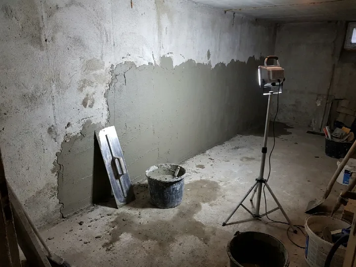 Application d’un mortier d’étanchéité sur le mur d’une cave